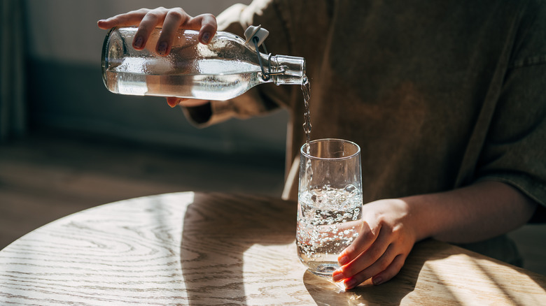 person pouring a glass of water