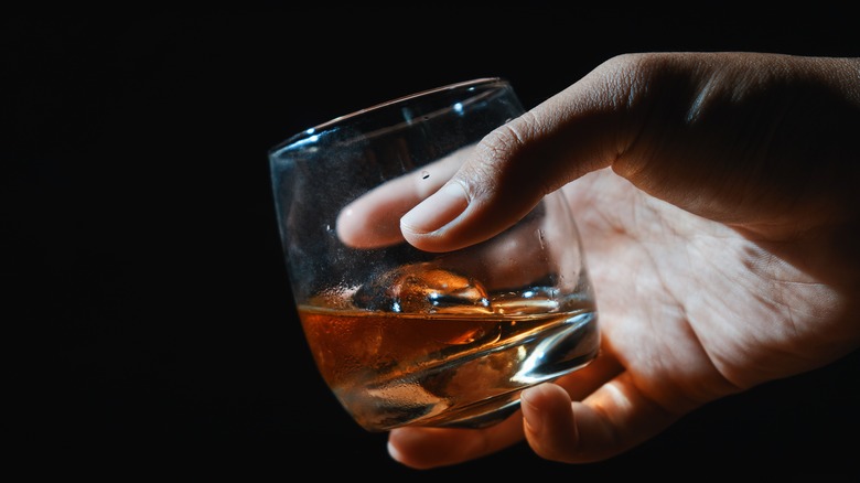 hand holding whiskey glass