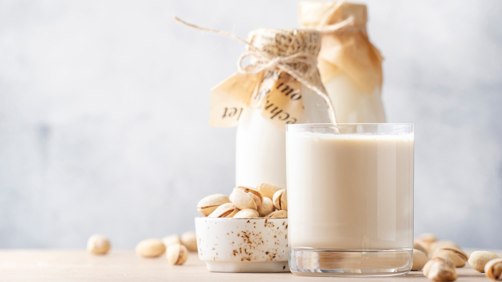 Glass of pistachio milk on table