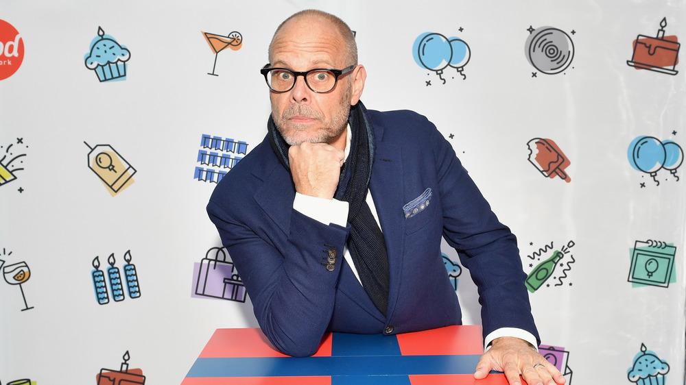 Alton Brown leaning on a box