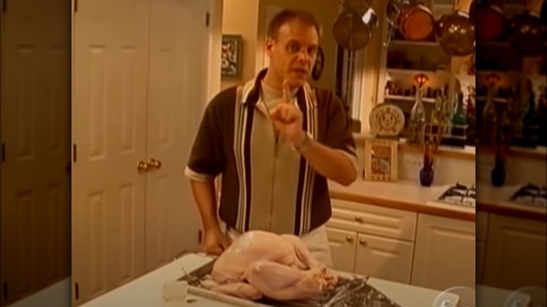 Alton Brown standing over turkey