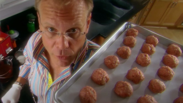 Alton Brown holding meatball pan