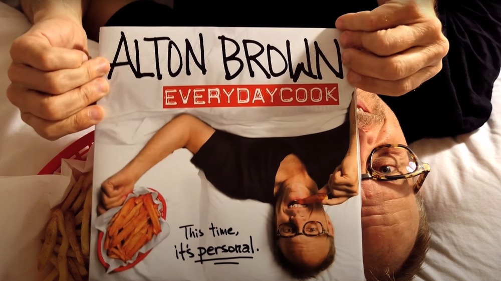 Alton Brown holding cookbook