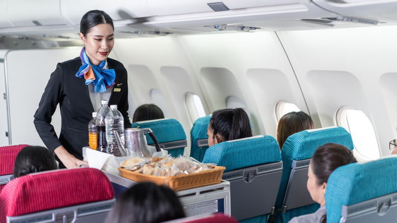 flight crew serving food on an airplane