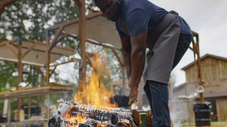 American Barbecue Showdown contestant lighting a fire