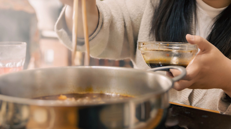 Person cooking dark broth