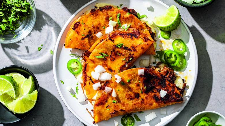 Plate of quesadillas with lime and jalapeno