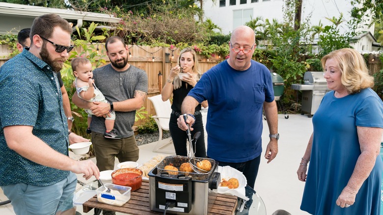 Andrew Zimmern cooking with a family