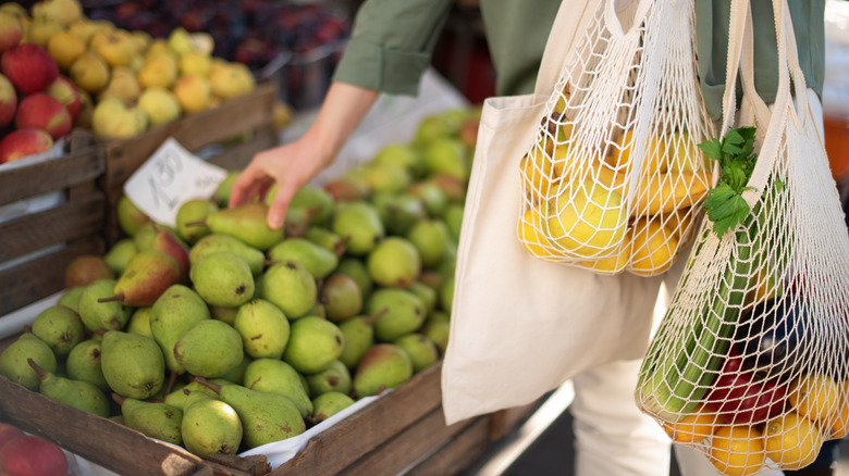 Person shopping for food with reusable bags 