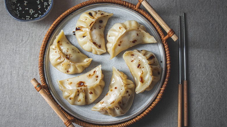 Gyoza potstickers in steamer basket with chopsticks