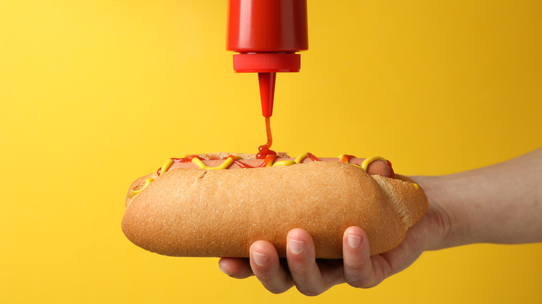 Putting ketchup on hot dog