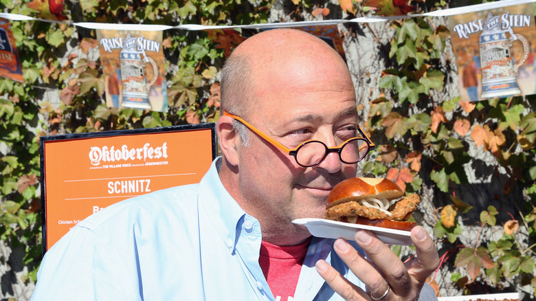 Andrew Zimmern sniffing a plate of food