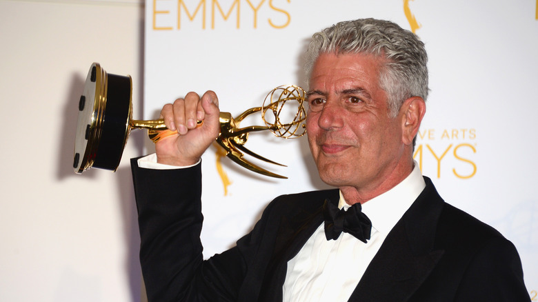 Anthony Bourdain holding an Emmy