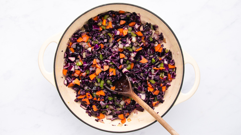 Sauteing red cabbage, carrot, celery, and onion in soup pot