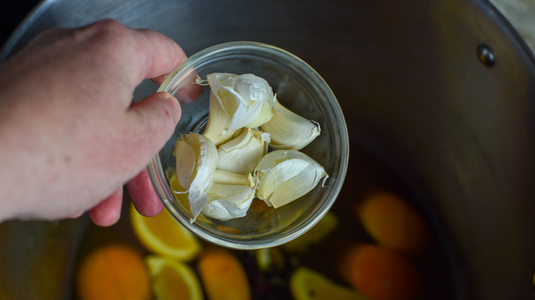 adding garlic to the pot