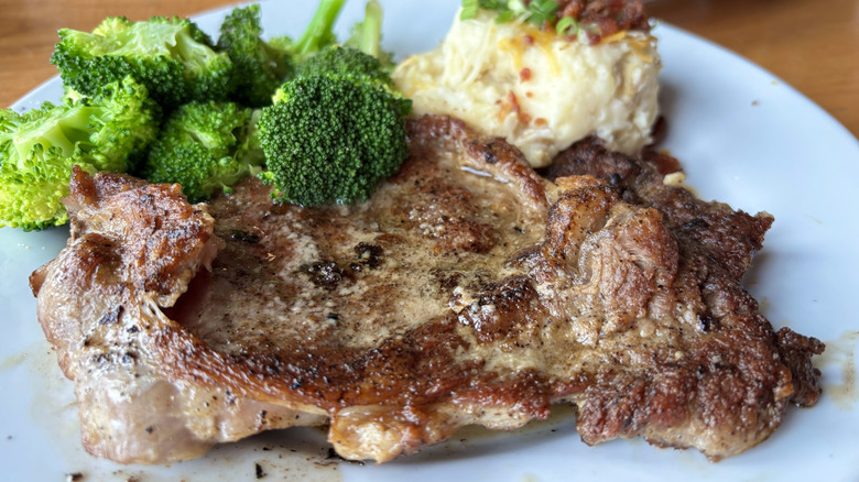 Ribeye steak on plate with broccoli and mashed potatoes