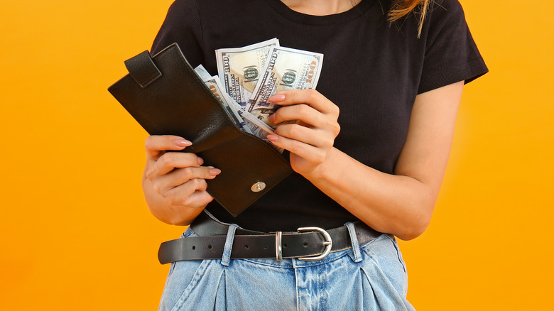 woman putting money in wallet