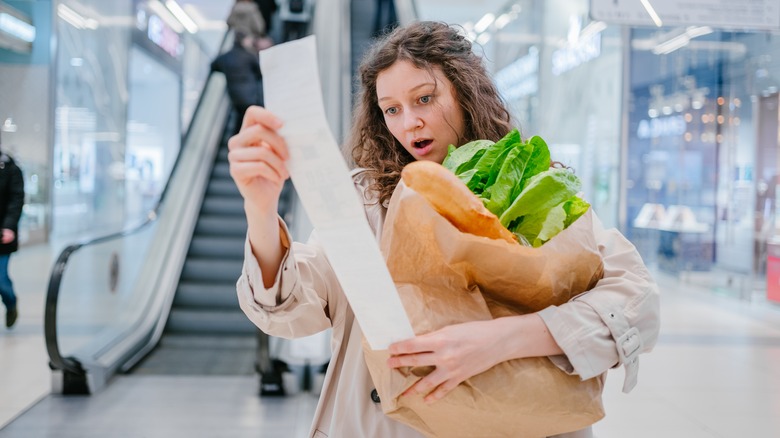 woman in shock at paper receipt 