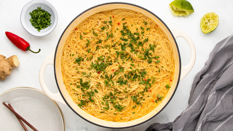 Coconut curry noodles with cilantro garnish in casserole dish