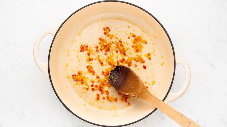 Chopped chile, garlic, and ginger frying in casserole pot