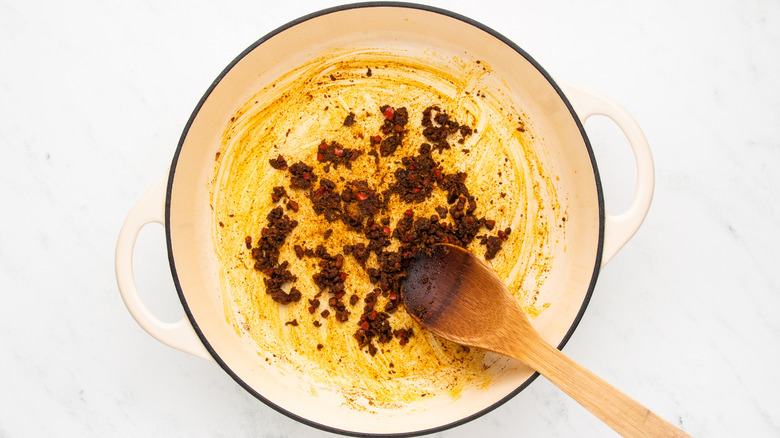 Aromatics and spices frying in casserole pot