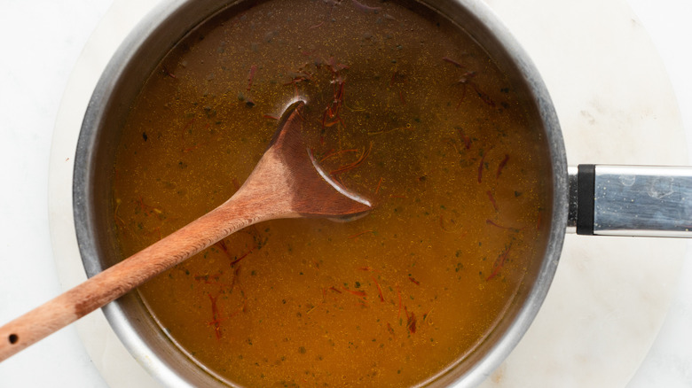 broth and saffron in saucepan