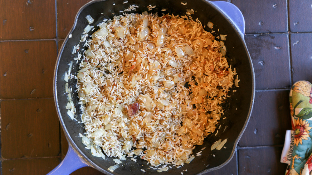 cooking rice and onions in pan