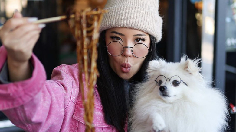 Ashley Yi with chopsticks and dog