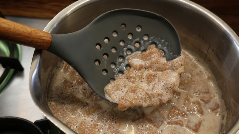 straining cereal from saucepan