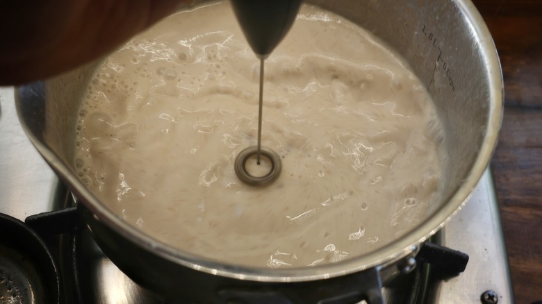 milk frother in saucepan of cereal milk