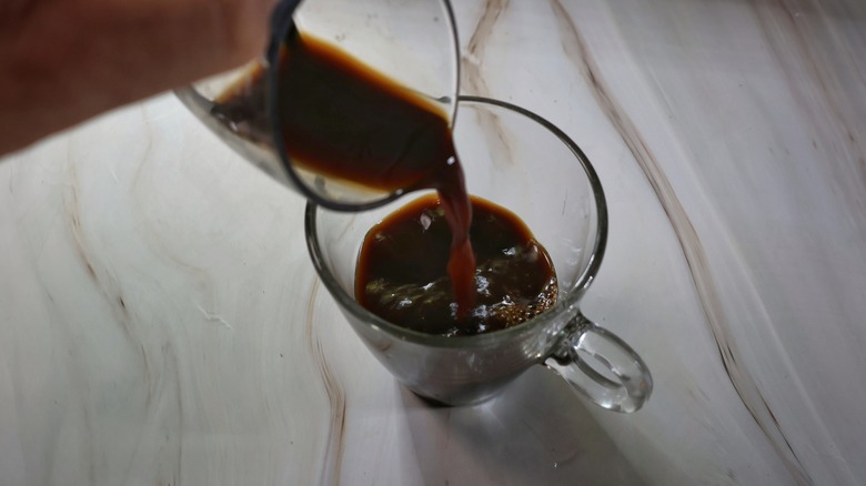 pouring espresso into mug