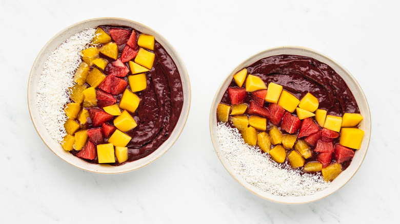 Two mango citrus açaí smoothie bowls