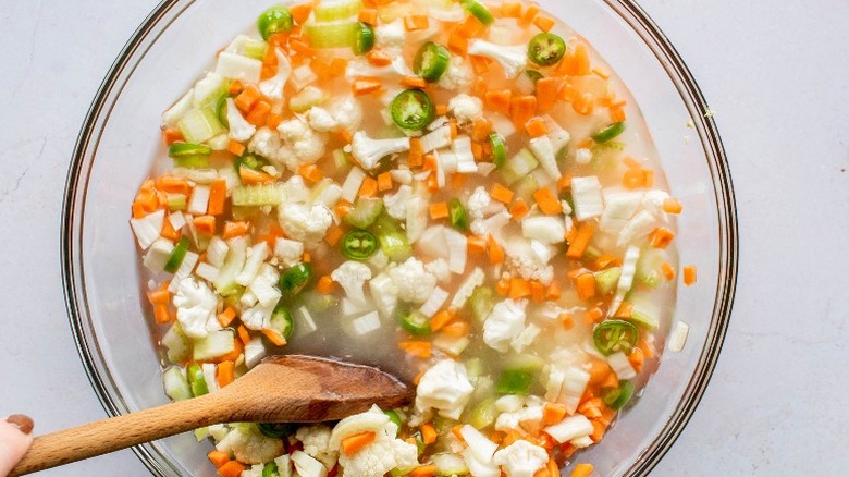 wooden spoon stirring chopped vegetables