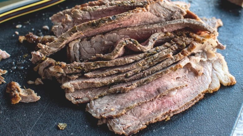 thinly sliced roasted beef on cutting board