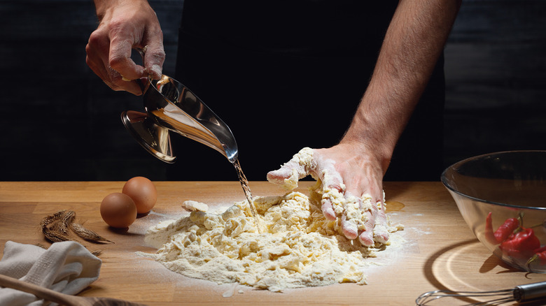 Chef adding water to flour for gravy