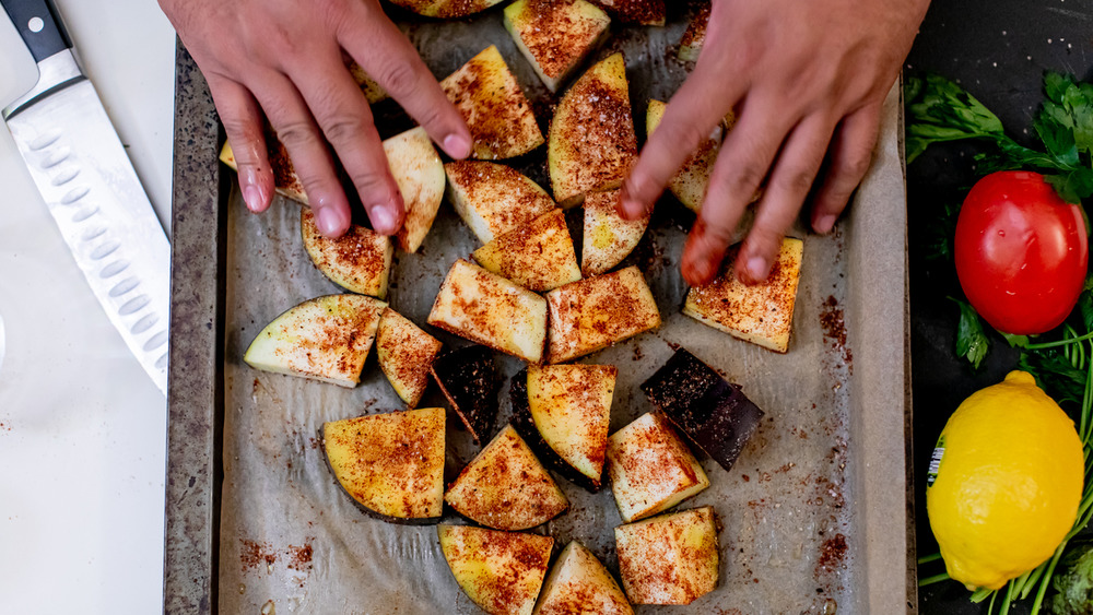 adding spice to eggplant for baba ganoush