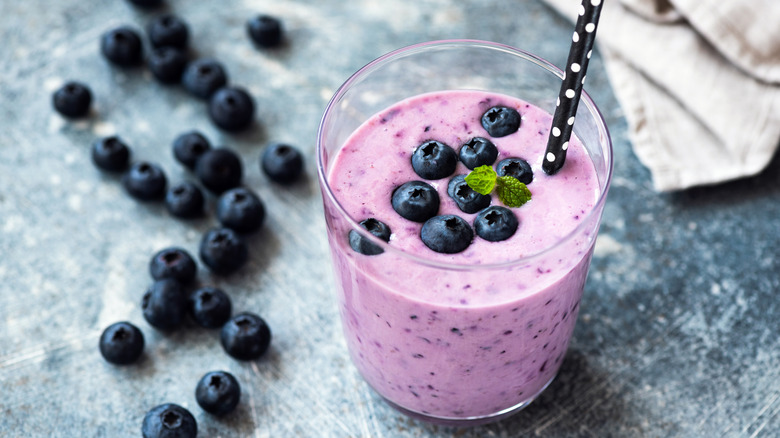 Blueberry smoothie in glass with polka dot straw