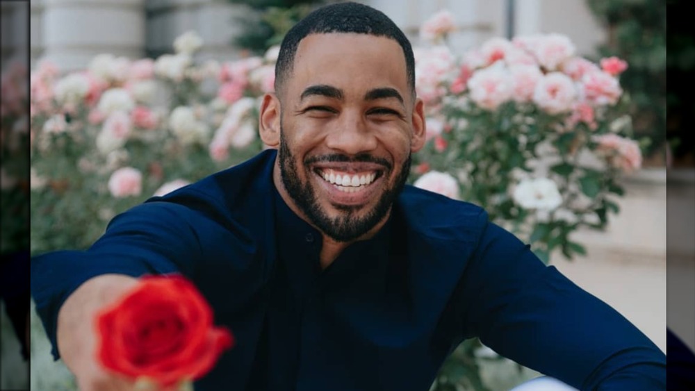 Mike Johnson smiling, holding a rose