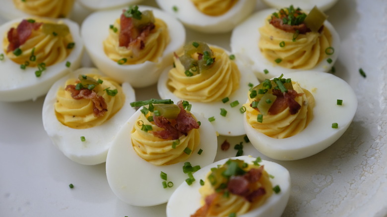 Deviled eggs with bacon, jalapeno, and chive toppings