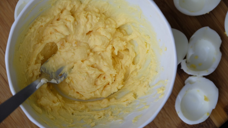 Yellow mixture sits in a bowl beside egg whites