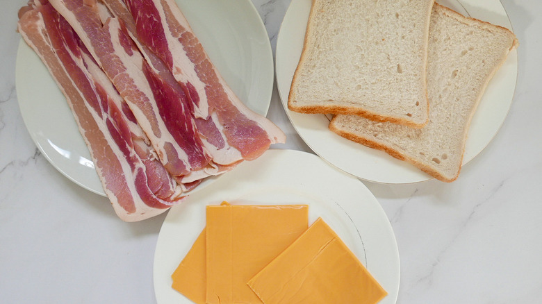 Bacon, bread, and cheese on plates