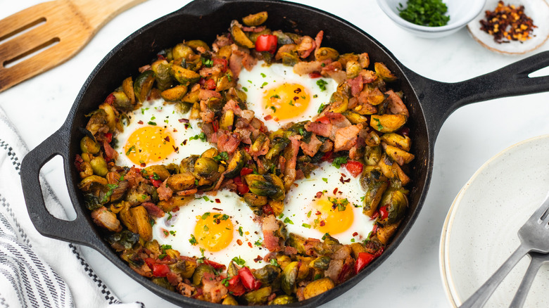 Brussels sprouts hash with eggs in skillet