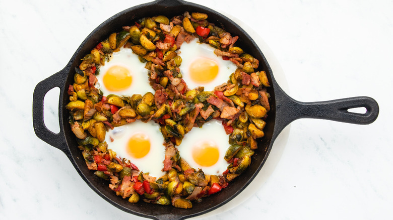 Brussels sprouts hash with eggs in skillet