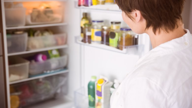 woman looking into a fridge