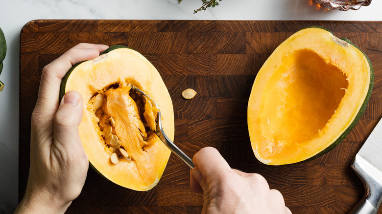 Scooping seeds out of acorn squash