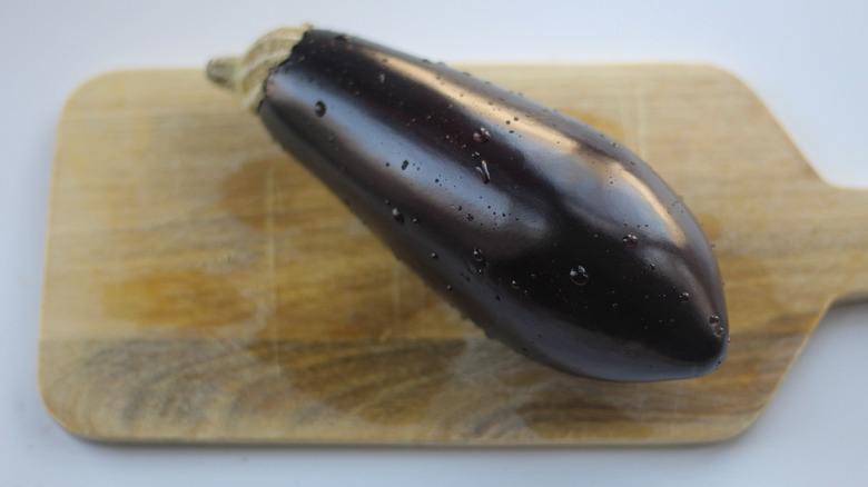 An eggplant placed on a cutting board.