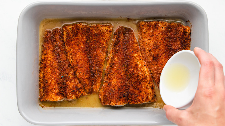 Lime juice being poured over baked tilapia