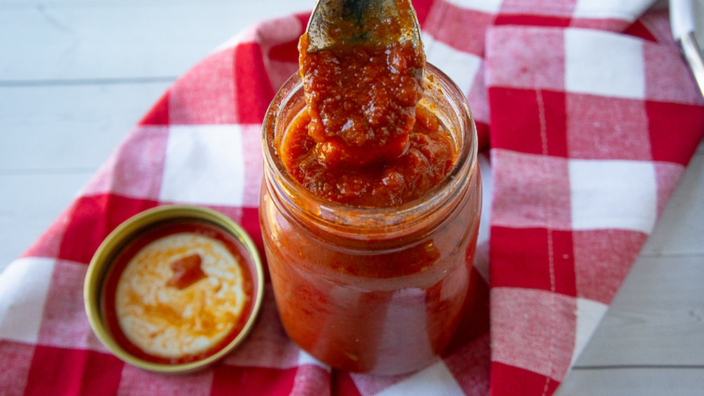 a jar of marinara sauce with a spoon dipping into it