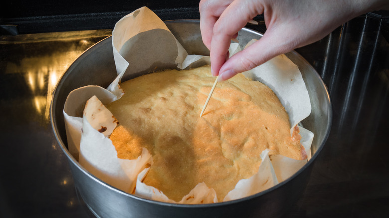 Inserting toothpick into cake