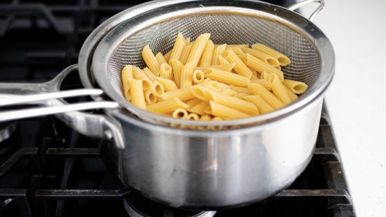 boiled penne pasta in colander